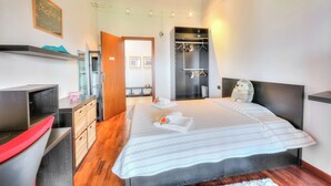 Ein Schlafzimmer mit Bett, Kleiderschrank, Schreibtisch und Spiegel.