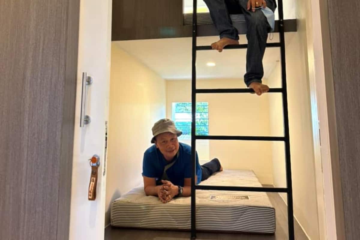 Una habitación con literas, una escalera y un cartel que dice 'Relax' en la puerta.