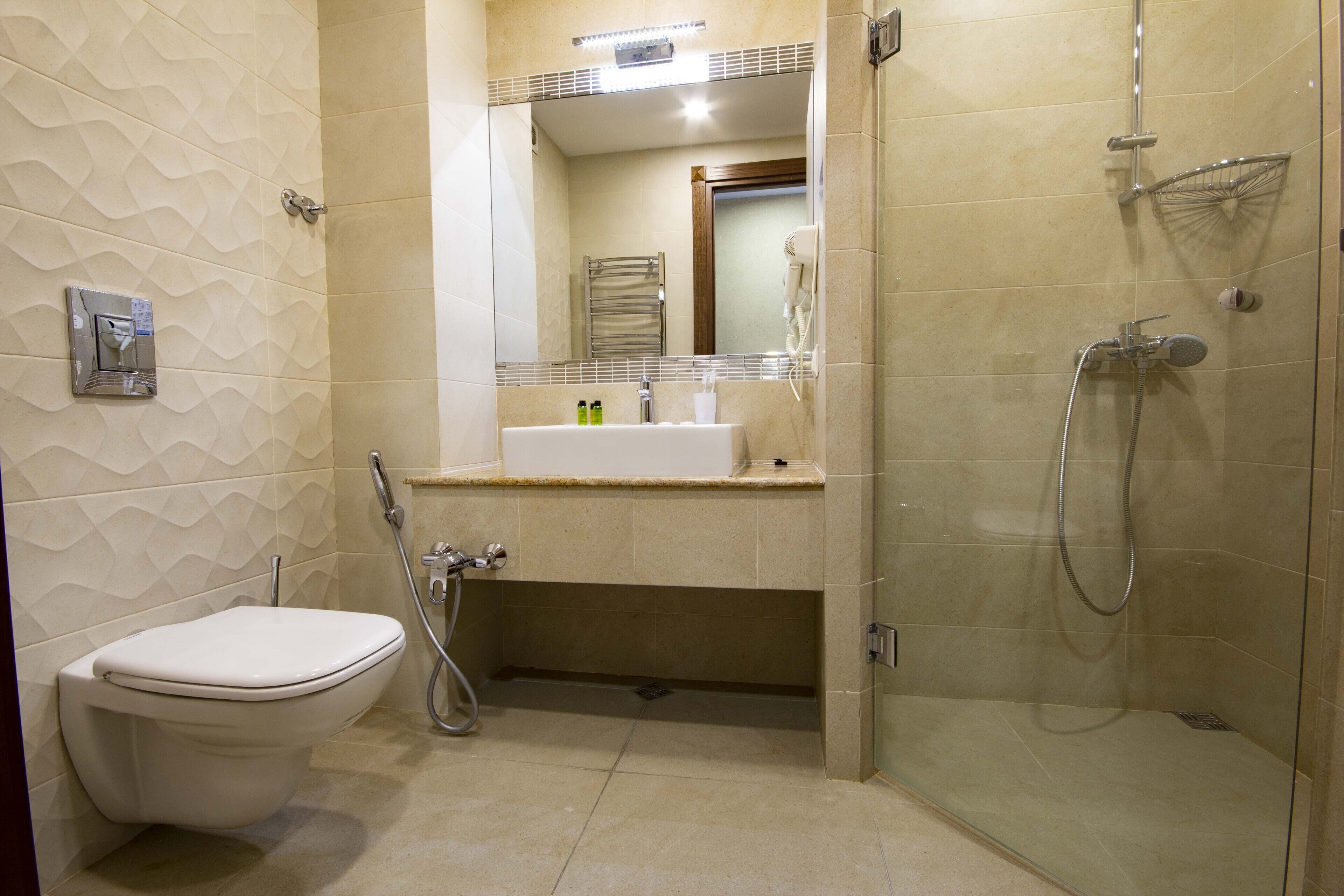 Un baño moderno con inodoro, lavamanos y zona de ducha.