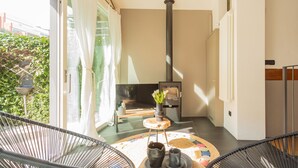 Una sala de estar moderna con chimenea, televisor y vista a zonas verdes.