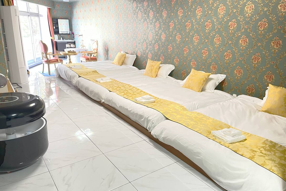 A hotel room with a large bed, a desk, and a chair.