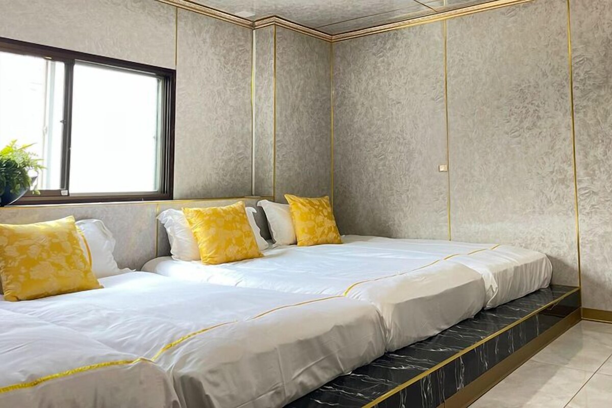 A modern hotel room with a large bed, a window, and a marble floor.
