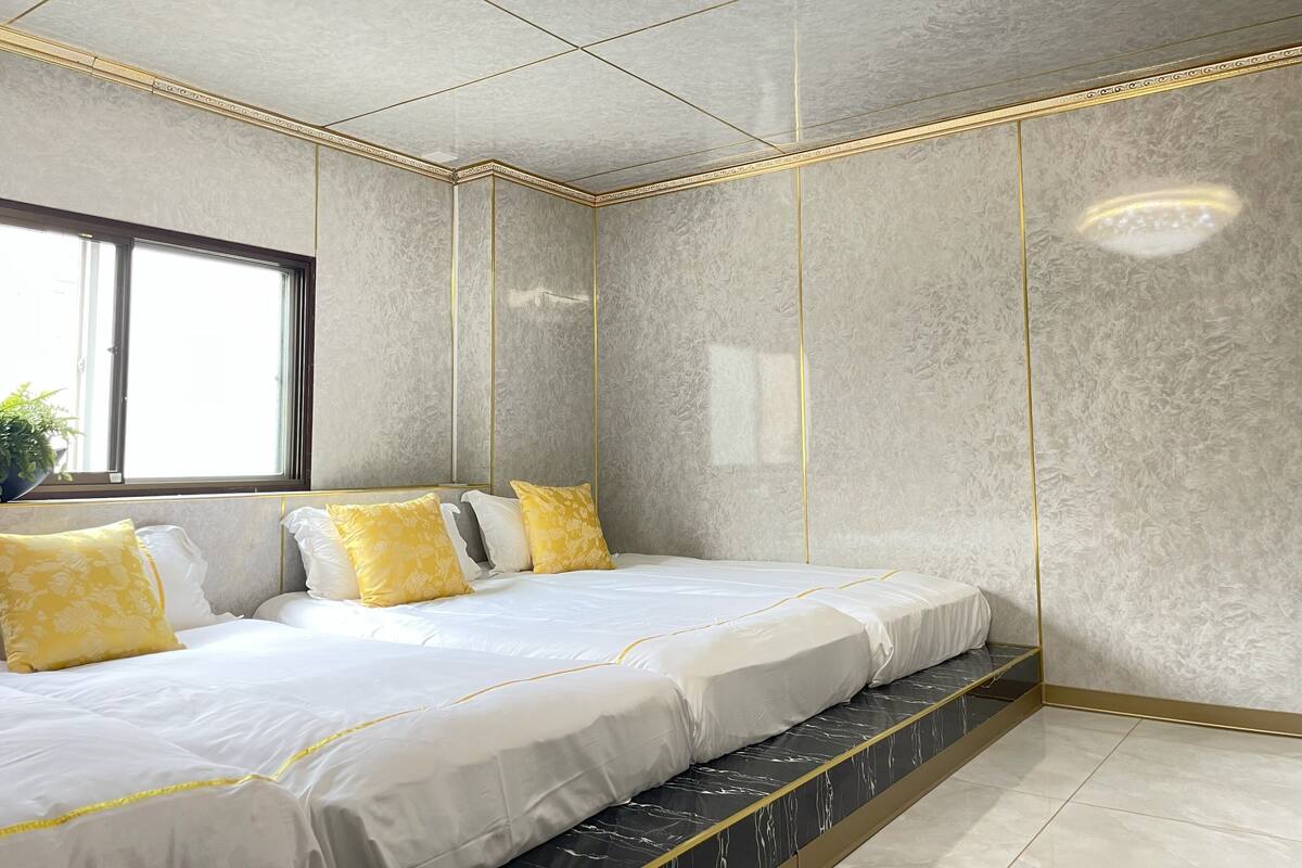 A bedroom with a bed, a window, and a plant.