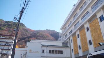 A multi-story building with balconies and a mountain in the background.