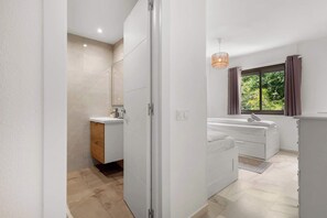 Bathtub, hair dryer, towels, toilet paper