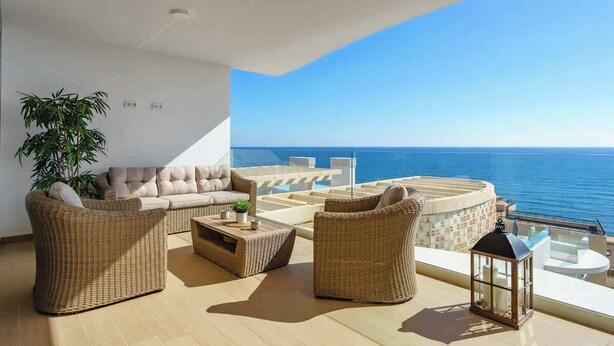 A modern living room with a sofa, two armchairs, a coffee table, and a small table with a plant. There is a large window overlooking the ocean. - Exclusive Seaview Apt by Costarentals - Ref 02 (Fuengirola)