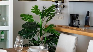 A dining table set with white plates, bowls, and wine glasses, surrounded by woven placemats. - Exclusive Seaview Apt by Costarentals - Ref 02 (Fuengirola)