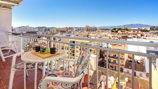 A balcony with a table, chairs, and a view of a cityscape. - Relaxing Getaway by Costarentals - Ref 169 (Fuengirola)