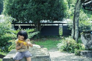 Children can play among lush plants and trees in our serene garden.