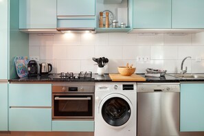 A kitchen with a Bosch washing machine, a Siemens dishwasher, a stove, and a coffee maker.