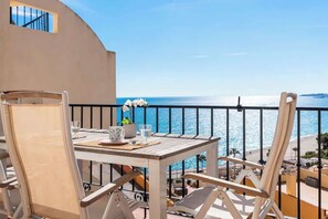 A balcony with a table set for two, overlooking a beach and the sea. - Penthouse Near the Beach by Costarentals - Ref 193 (Benalmádena)