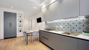 A modern kitchen with grey cabinets, a white countertop, and a patterned backsplash. - ‘Victoria Family’ Apartment with Balcony, Wi-Fi & Air Conditioning (Diano Marina)