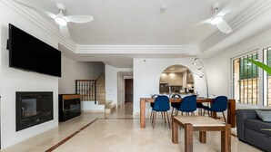A spacious living area with a dining table, chairs, a sofa, a fireplace, and a television. - 'Villa In Los Flamencos' with Private Pool, Wi-Fi and Air Conditioning (Mijas Costa, Riviera del Sol)