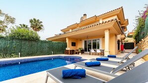 A swimming pool with lounge chairs and a covered patio area. - 'Villa In Los Flamencos' with Private Pool, Wi-Fi and Air Conditioning (Mijas Costa, Riviera del Sol)