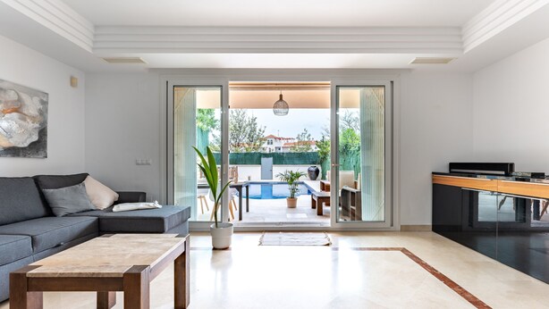 A modern living room with a sofa, coffee table, and a view of an outdoor pool area. - 'Villa In Los Flamencos' with Private Pool, Wi-Fi and Air Conditioning (Mijas Costa, Riviera del Sol)