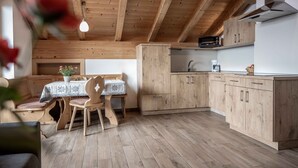 Un intérieur en bois comprenant un coin repas, une cuisine et des placards intégrés.