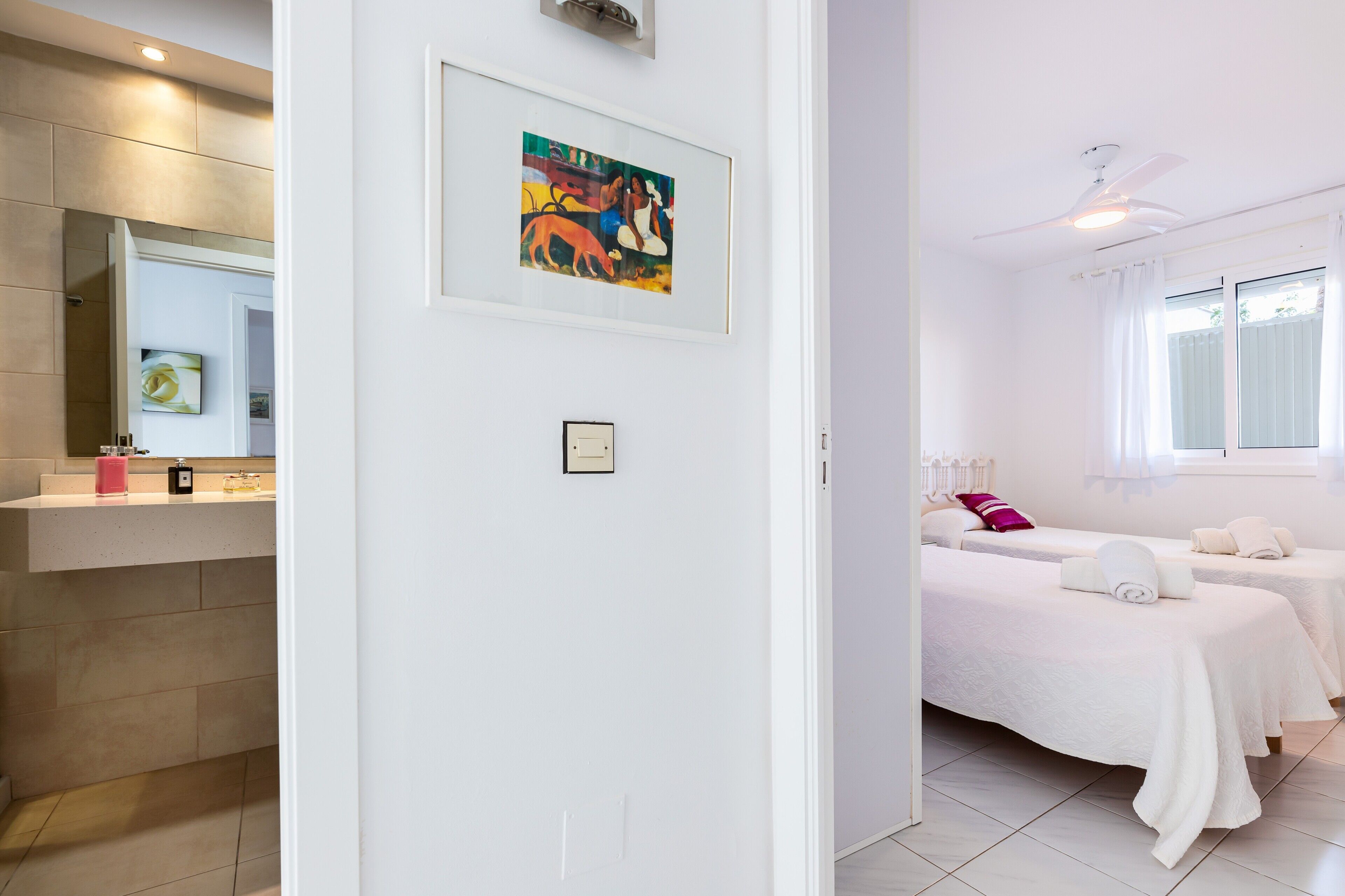 Ein Hotelzimmer mit Bad, einem Bett mit Kissen und einem Deckenventilator.