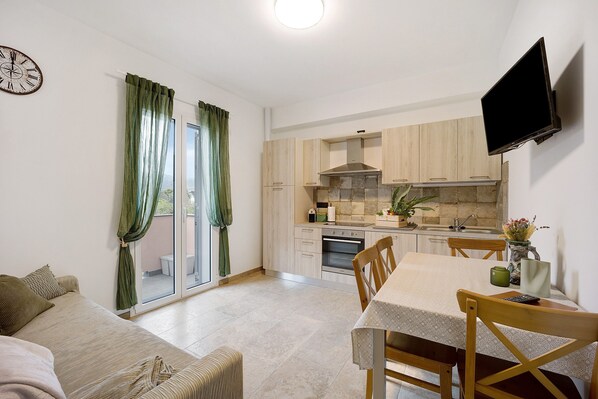 A compact living space with a kitchenette, a dining area, and a sofa.