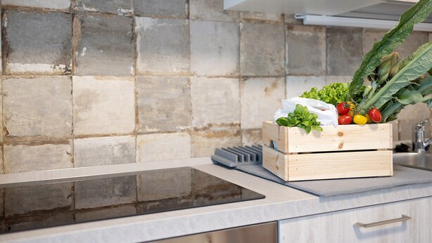 A kitchen with a stone backsplash, a wooden crate with vegetables, a digital scale, and a modern stove. - Holiday Apartment "Antichi Ricordi - Da Angela" with Balcony, Shared Pool & Wi-Fi (Andora)