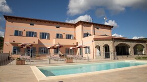 A two-story building with a swimming pool, outdoor seating, and a stone archway. - Holiday Apartment "Antichi Ricordi - Da Angela" with Balcony, Shared Pool & Wi-Fi (Andora)