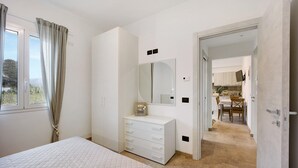 A bedroom with a bed, a dresser, a mirror, and a view of a dining area. - Holiday Apartment "Antichi Ricordi - Da Angela" with Balcony, Shared Pool & Wi-Fi (Andora)