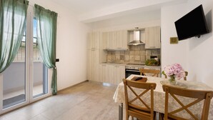 A modern kitchen with light wood cabinets, a stainless steel range hood, and a dining area with a table and chairs. - Holiday Apartment "Antichi Ricordi - La Stalla" with Terrace, Shared Pool & Wi-Fi (Andora)