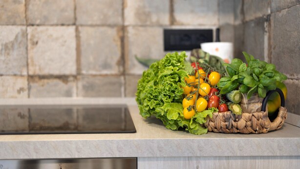 A kitchen counter with a woven basket containing vegetables and herbs. - Holiday Apartment "Antichi Ricordi - La Stalla" with Terrace, Shared Pool & Wi-Fi (Andora)