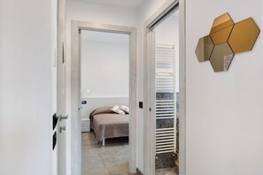 Une chambre à coucher avec un lit, une porte et un élément décoratif géométrique fixé au mur.