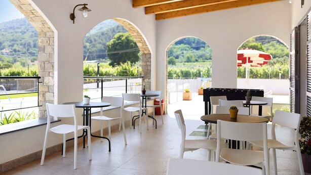 An outdoor patio with white chairs and tables, stone arches, and a view of a vineyard. - Holiday Apartment "Antichi Ricordi - Il Fienile" with Balcony, Shared Pool & Wi-Fi (Andora)
