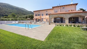 A pool area with a stone patio, a covered seating area, and a building with a stone facade. - Holiday Apartment "Antichi Ricordi - Il Fienile" with Balcony, Shared Pool & Wi-Fi (Andora)