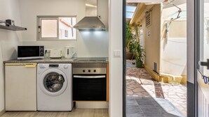 Cocina compacta con lavadora, microondas y horno.