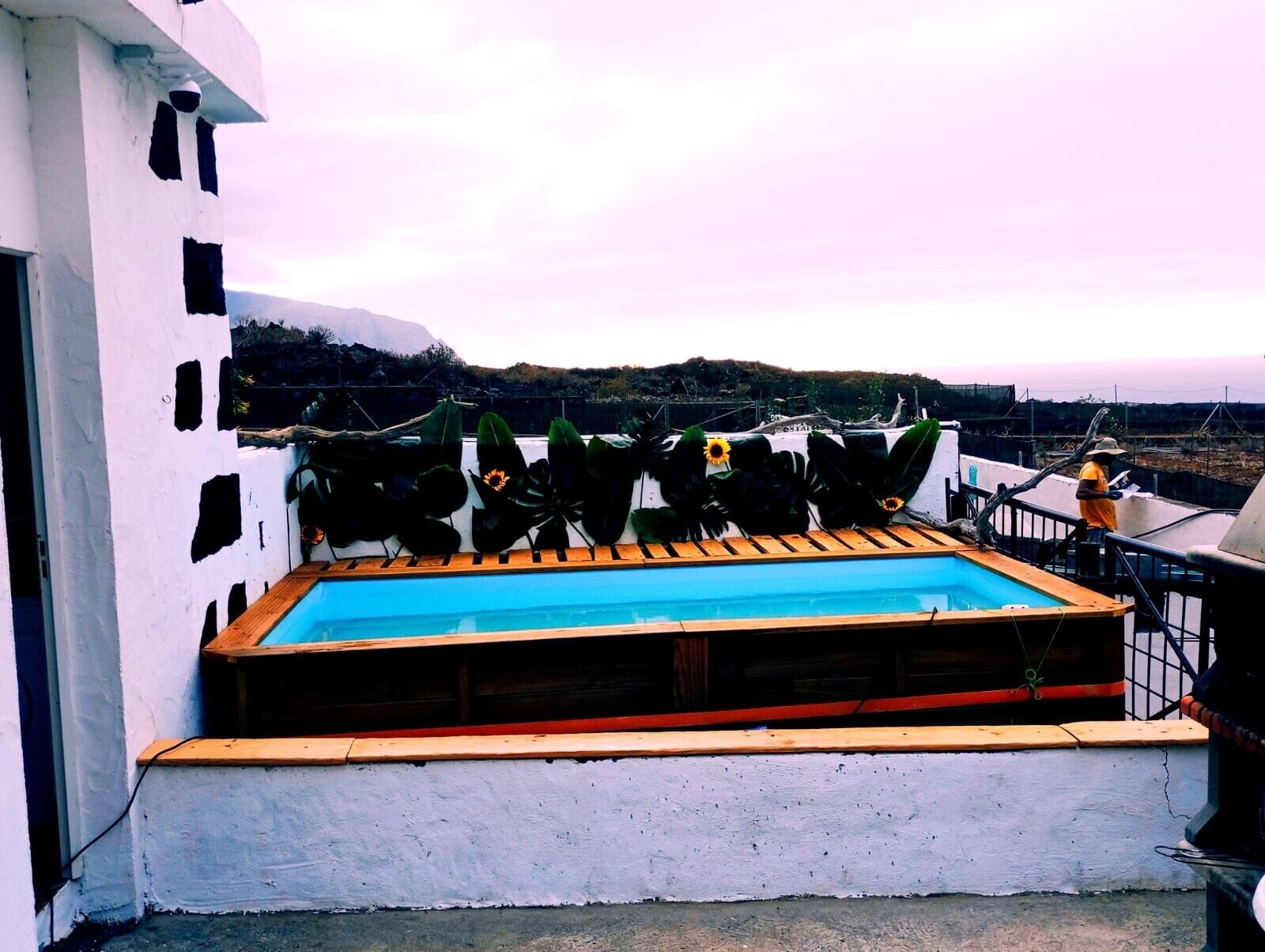 Ein Pool auf dem Dach mit einer Holzterrasse und Blick auf die umliegende Landschaft.