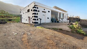 Un edificio moderno con fachada blanca, ventanas de vidrio amplias y techo plano.