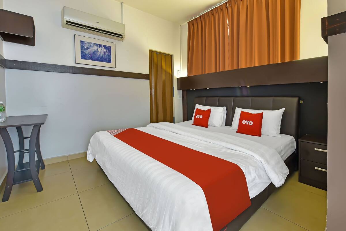 A hotel room with a bed, a desk, and a chair.