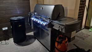 Eine moderne Küche mit integriertem Grill, einem Mülleimer und einer Gasdose.