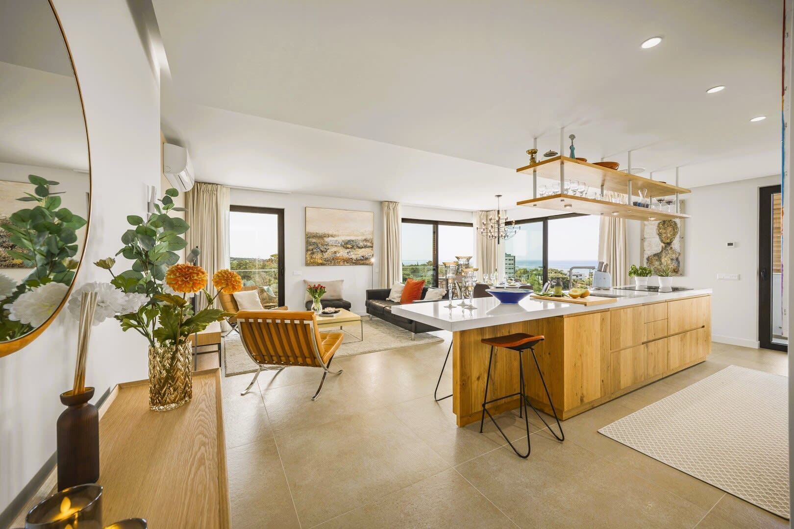 Una cocina moderna con una isla central, ventanas amplias y vista al mar.