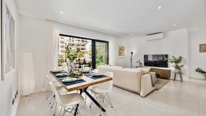 Eine moderne Wohnung mit Essbereich, Wohnzimmer und großen Fenstern.