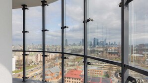 A high-rise interior with large windows offering a cityscape view. - Modern Studio with Balcony | Parking | Close to EXPO XXI (Warszawa)