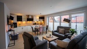 Un appartement moderne comprenant un coin repas, une cuisine et un salon.