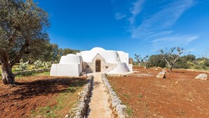 A white building with a stone pathway leading to an entrance. - 3226 Trullo Sorrentino Luxury Spa by Perle di Puglia (Ostuni)