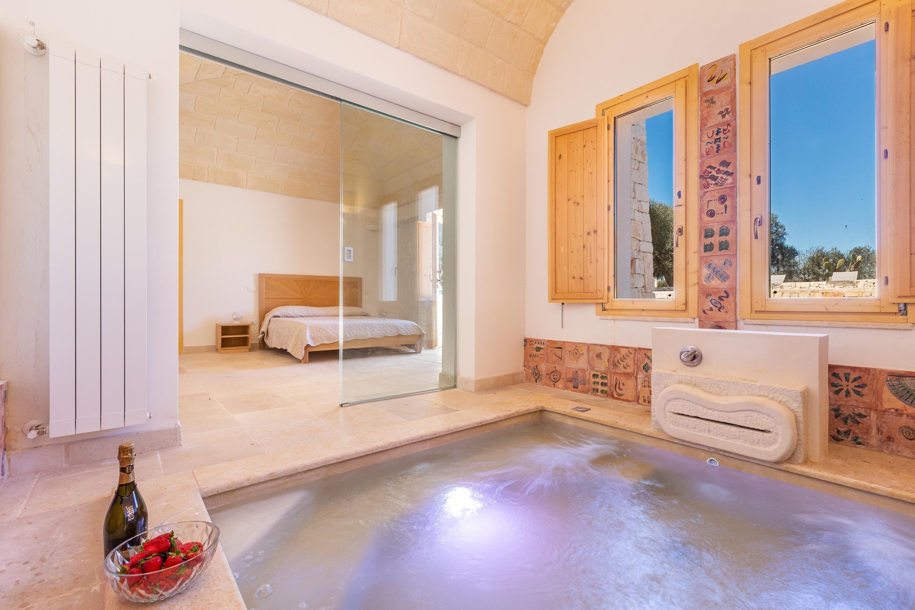 A modern bathroom with a glass shower enclosure, a bathtub, and a wooden vanity with a sink.