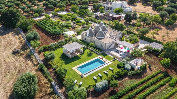 An aerial view of a property with a swimming pool, garden, and olive groves. - 3224 Trulli Almaviva by Perle di Puglia (Cisternino)