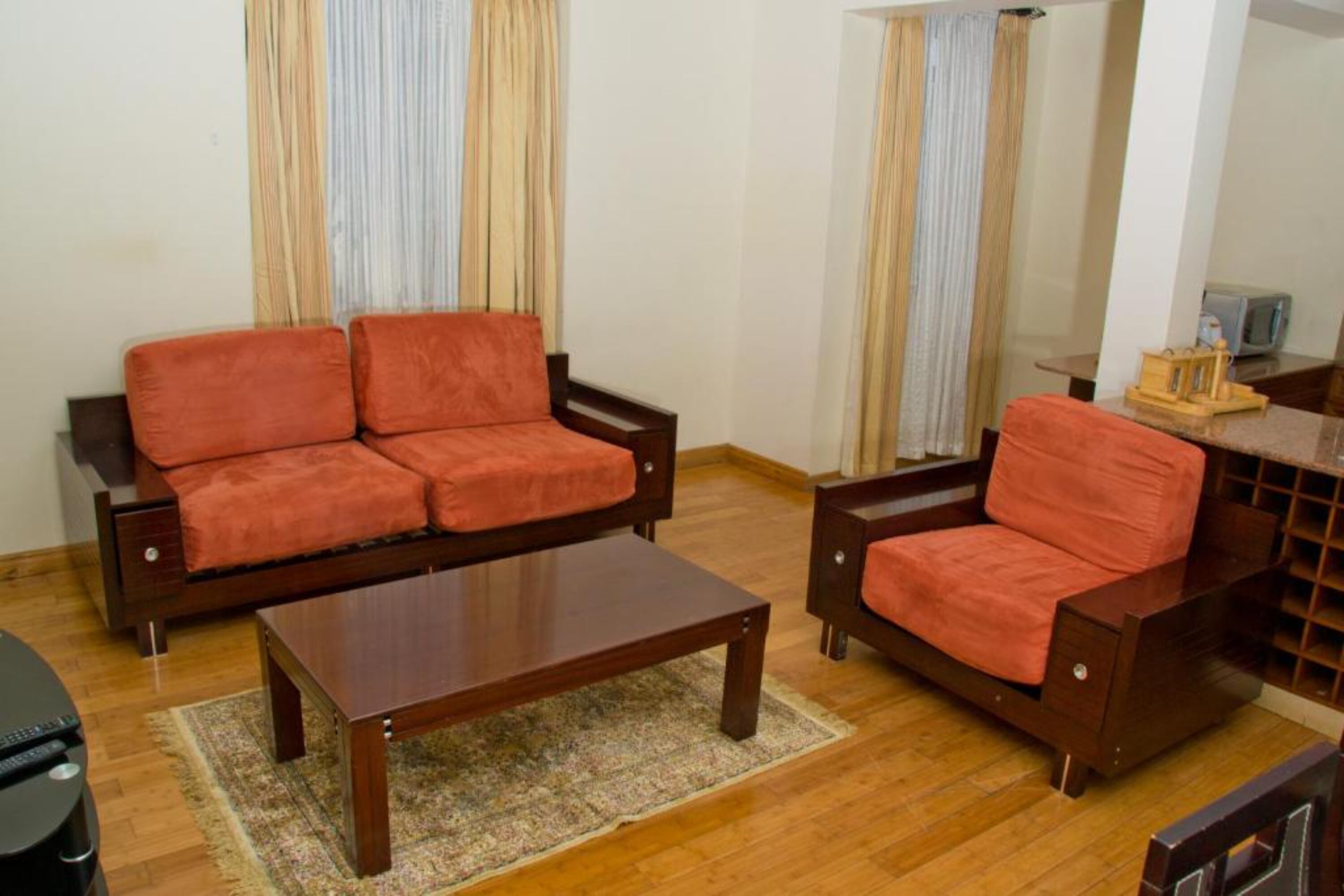 A living room with a sofa, armchair, coffee table, and a TV stand.