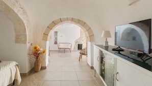 Une pièce confortable avec un téléviseur, un canapé et une table à manger.