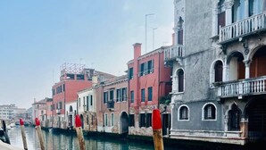 Un canal amb edificis històrics, un passeig de pedra i una gòndola amarrada al final.