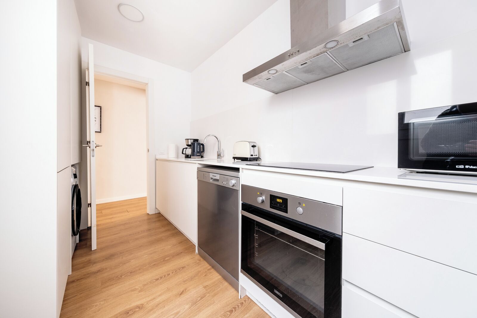 A modern kitchen with a dishwasher, oven, and microwave.