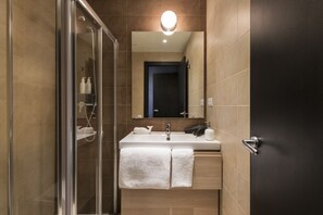 Eenvoudig appartement | Badkamer | Een douche, gratis toiletartikelen, een haardroger, handdoeken
