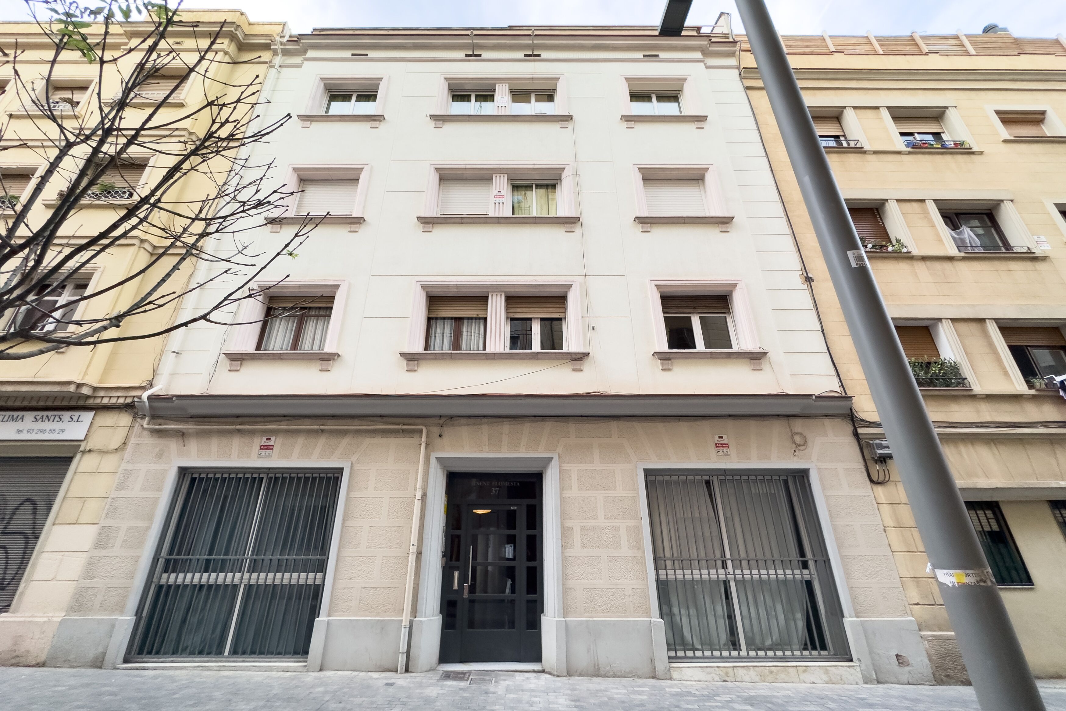 Un immeuble à plusieurs étages, doté d’une façade beige, de grandes fenêtres et d’une entrée centrale.