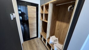 A modern walk-in closet with a combination of black and wooden doors, built-in shelving, and a wooden floor. - Business Hotel Prijedor (Prijedor)