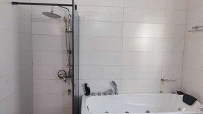 Chuveiro, banheira de hidromassagem, toalhas de banho 
